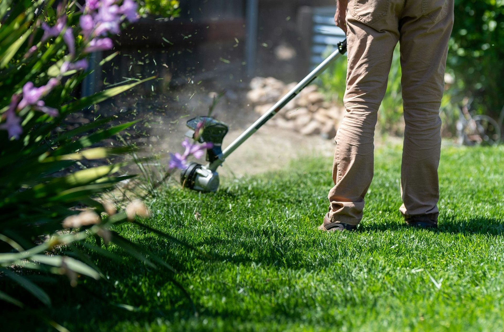 a man using a lawn mower to cut grass